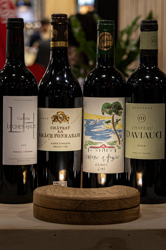 quatre bouteilles de vin rouge éclairées