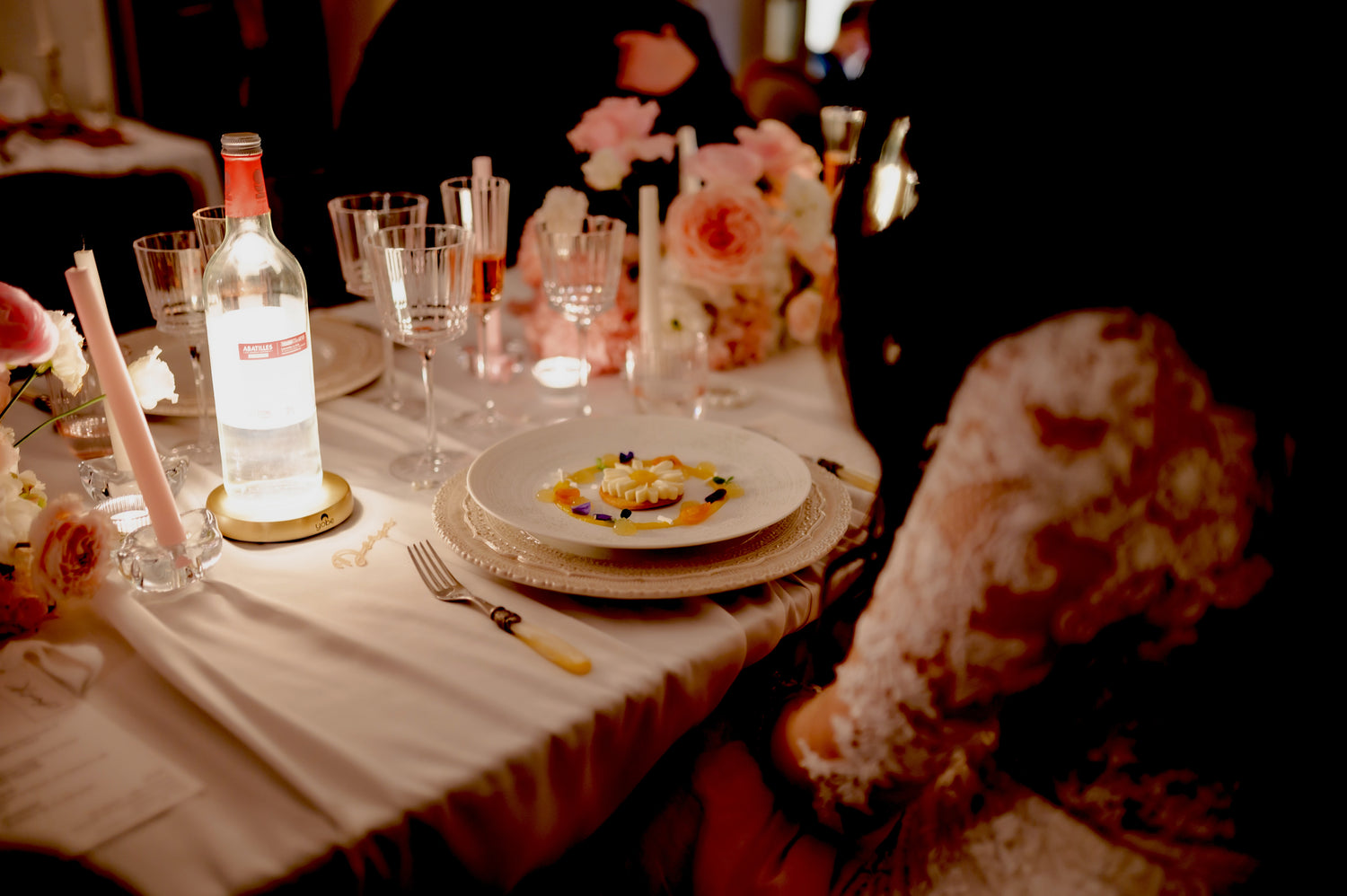 buteille lumineuse sur un socle avec logo Yobe posés sur une table de mariage dans un cadre premium chic et fleuri 