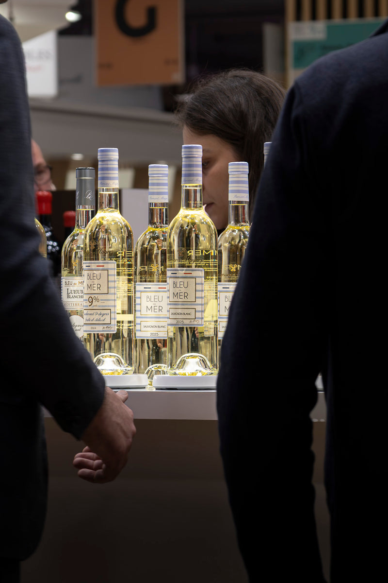 Bouteilles de vin blanc bleu de mer par bernard magrez, illuminée par un support lumineux