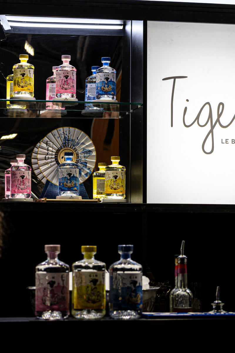 bouteilles de Gin de la marque ETSU posées sur des étagéres transparentes en verre dans un bar d'ambiance japonisante 